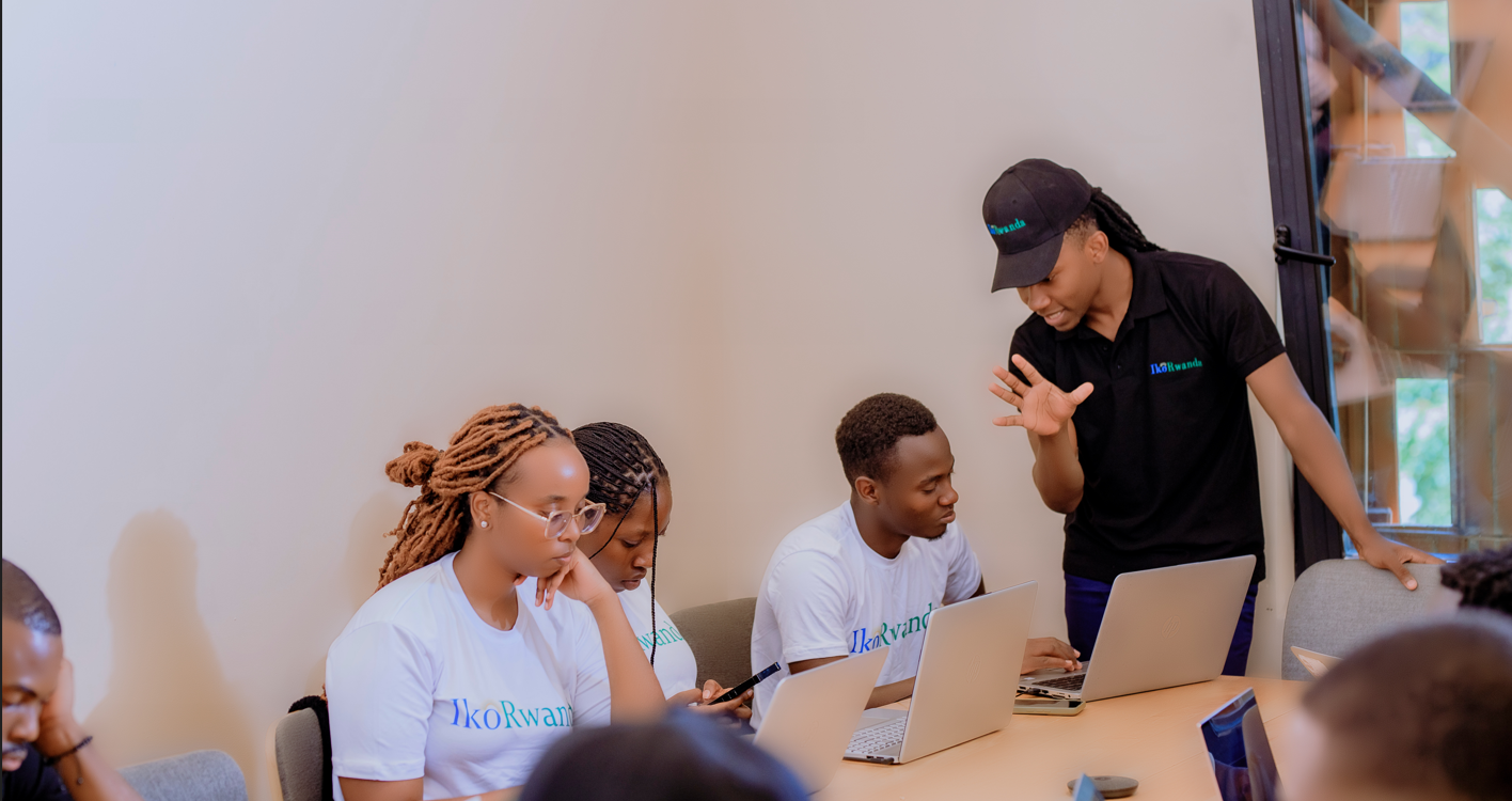 IkoRwanda mentor guiding trainees working at laptops during a hands-on session