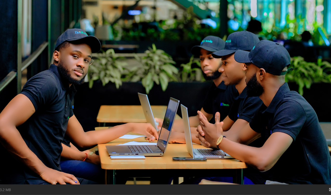 IkoRwanda team working together at laptops in an outdoor cafe setting