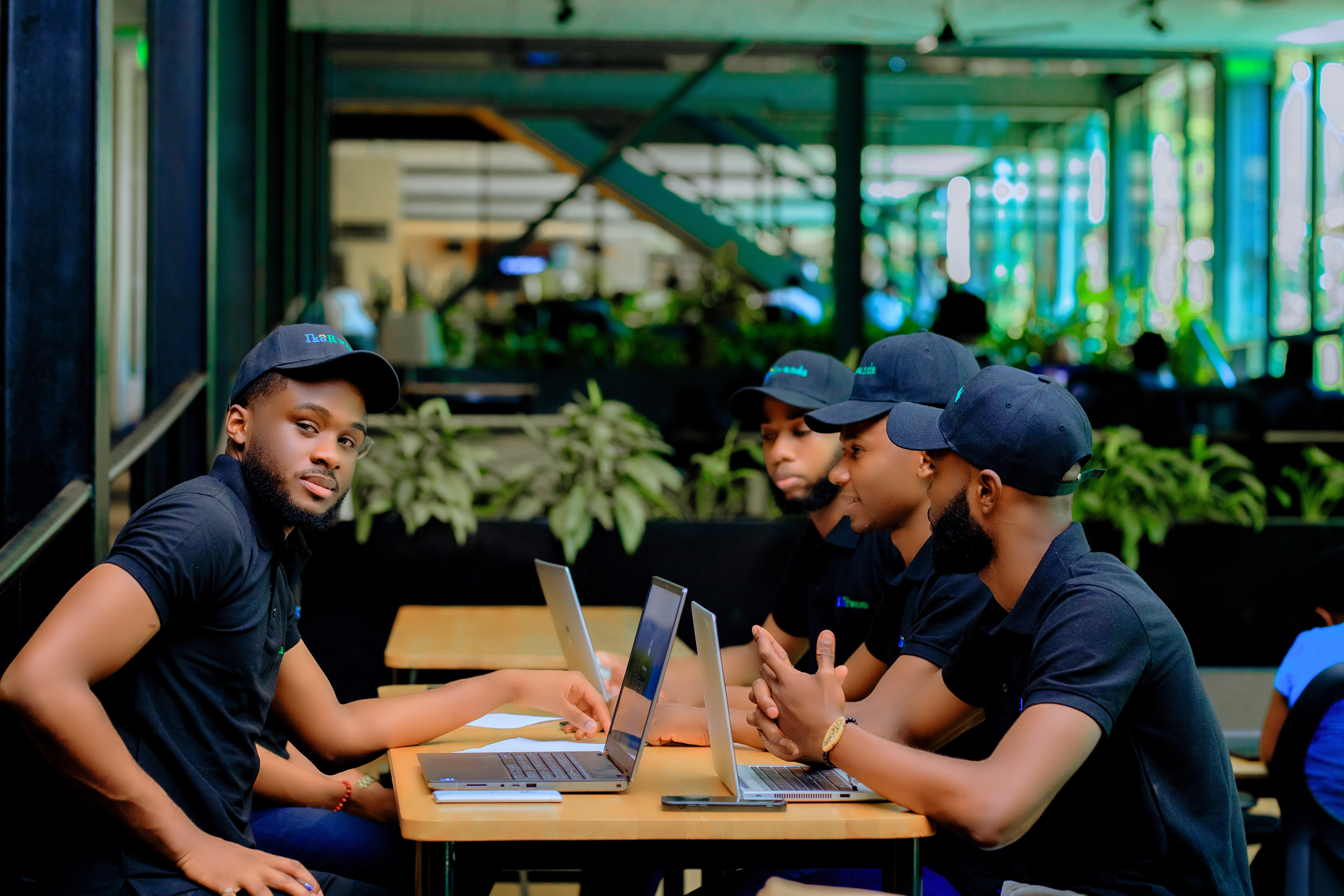 IkoRwanda developers in a strategy discussion at a cafe with laptops