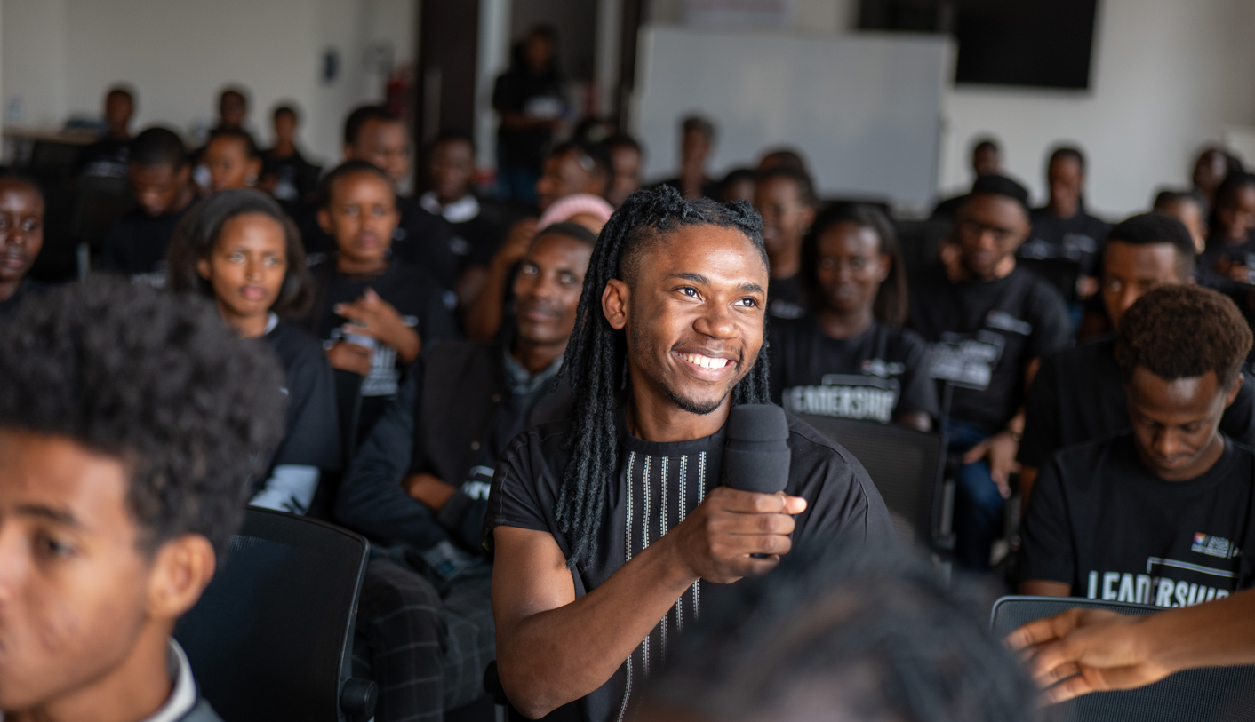 Mathias speaking to a packed room of over 50 trainees at an IkoRwanda session